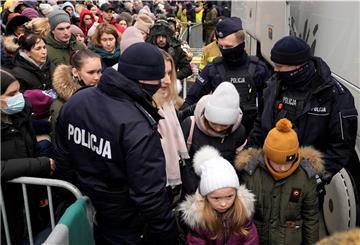 Flüchtlinge, die vor dem Krieg in der Ukraine geflohen sind, drängen sich, um in einen Bus zu steigen und den Grenzübergang Korczowa in Polen zu verlassen.