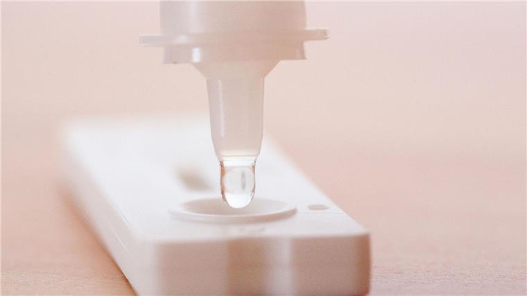 Neue Hotline für Long-Covid- und Post-Vac-Betroffene Flüssigkeit wird auf einen Antigen-Schnelltest gegeben.