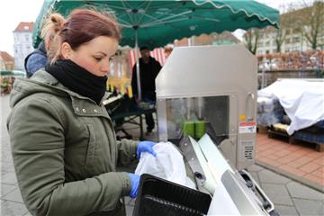 Flugs durch die Schälmaschine: Die Marktfrau tütet die bereits geschälten Stangen ein. Die Maschine kostet soviel wie ein Kleinwagen.