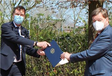 Fototermin mit Masken: Verkehrsstaatssekretär Enak Ferlemann (rechts) übergibt Landrat Kai-Uwe Bielefeld den Förderbescheid zum Ausbau schnellen Internets. 