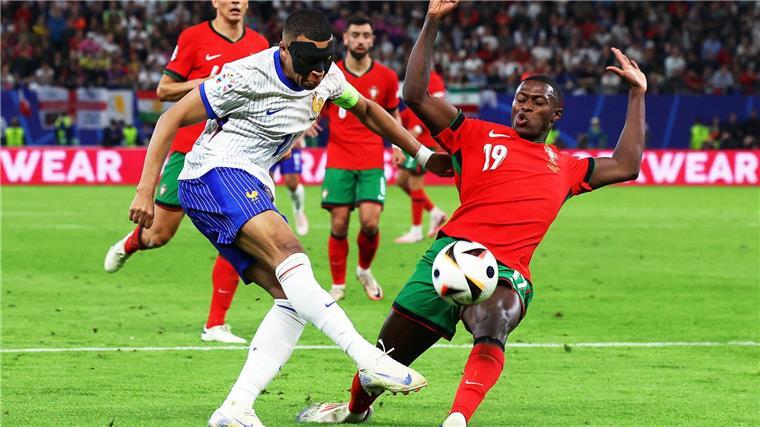 Frankreichs Kylian Mbappé (l) und Portugals Nuno Mendes kämpfen um den Ball.