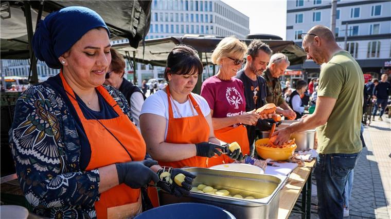 Freiwillige Helfer bereiten bei der Aktion „Offenes Essen für alle“ der Bremer Suppenengel.