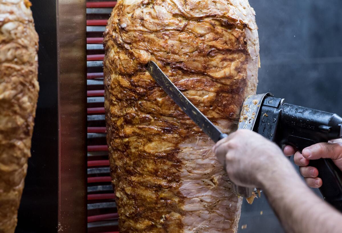Dönerspieße drehen sich in einem Imbiss.