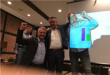 Jubel in einem Saal vor einer Leinwand