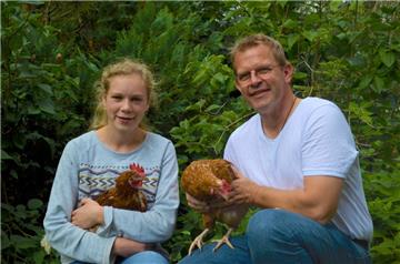 Friederike und ihr Vater Florian Palme begrüßen ihre neuen Familienmitglieder - zwei Hühner.