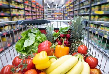 Obst und Gemüse liegt in einem Einkaufswagen.