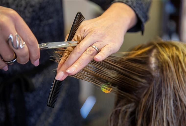 Bremerhaven: Gericht lässt Friseurläden geschlossen Eine Friseurin schneidet einer Kundin die Haare.