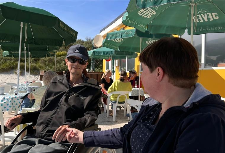 Ein Mann und eine Frau halten Händchen am Strand.
