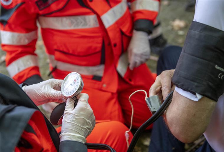 Ersthelfer messen bei einem Verletzten den Blutdruck