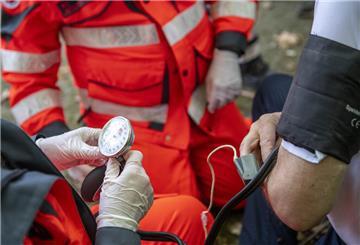 Ersthelfer messen bei einem Verletzten den Blutdruck