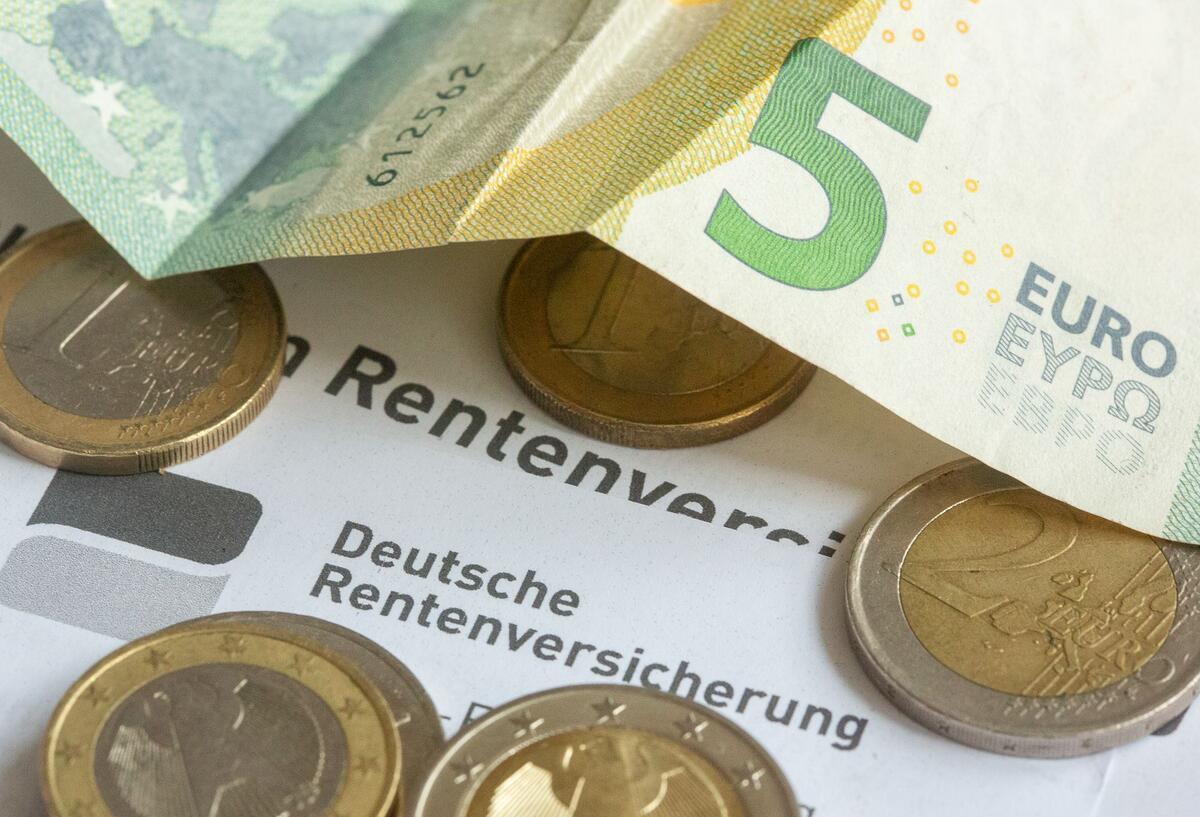 Münzen und eine Banknote liegen auf einer Renteninformation der Deutschen Rentenversicherung. Für eine bestimmte Gruppe von Senioren ist die komplette Rente in Gefahr. Betroffene müssen unbedingt handeln.