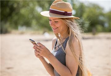 Frau mit Handy am Strand
