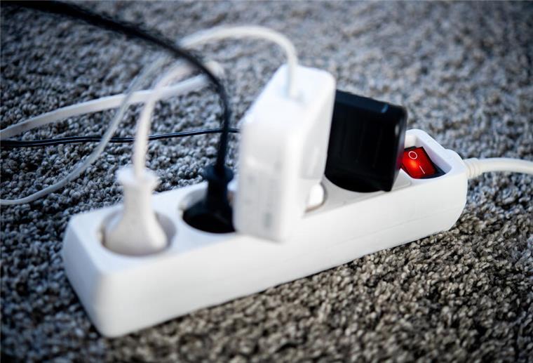 So können viele Bremerhavener mehr Geld für die Energierechnung bekommen Die Netzstecker verschiedener Geräte sind in einem Wohnzimmer in eine Steckdosenleiste gesteckt.
