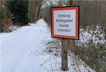 Ein Schild ist an einem verschneiten Weg zu sehen.