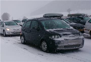 Autos stehen im Stau auf der schneebedeckten Fahrbahn