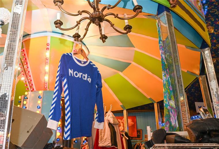 Ein blaues Trikot hängt an einem Kleiderbügel.