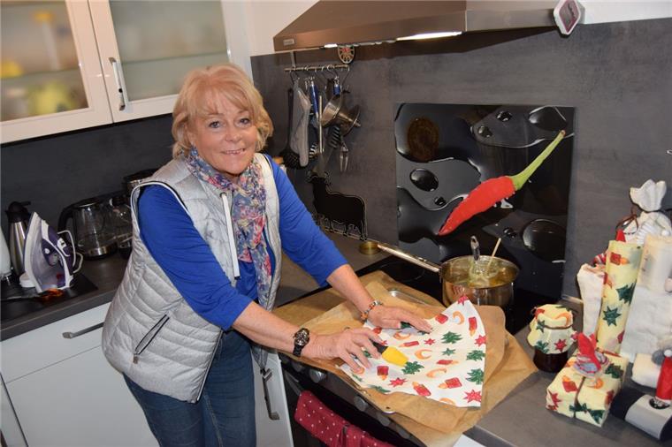 Tipps für ein umweltfreundliches Weihnachten aus dem Cuxland Eine Frau steht in einer Küche und hat Geschenkpapier in der Hand.