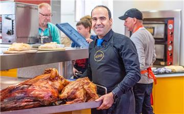 Gastronom Alexis Vaiou mit dem Spanferkelbraten beim großen Osteressen in Bremerhaven.