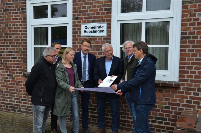 Gebäudemanager Michael Körner, Regionalplaner Marcel Bonse, Planerin Kerstin Alpers, Gemeindedirektor Henning Fricke, Bürgermeister Gerhard Holsten (von links) sowie Wirtschaftsförderer Christoph Reuther (rechts) gucken mit Siegfried Dierken vom Amt für regionale Landesentwicklung auf die Pläne für das Haus der Vereine in Heeslingen.