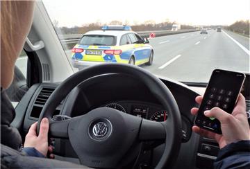 Gefährliche Ablenkung: Anstatt sich voll auf den Straßenverkehr zu konzentrieren, benutzt der Fahrer auch noch sein Handy.