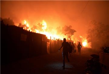 Geflüchtete rennen während ein Feuer im Flüchtlingslager Moria auf der Insel Lesbos brennt. Medienberichten zufolge stehen auch Wohncontainer in Flammen, weshalb die Behörden das Lager evakuierten. 
