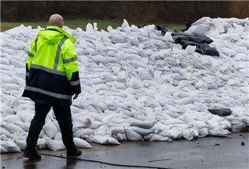 Gefüllte Sandsäcke liegen an einem Deich nahe der Weser. Der bereits über Tage anhaltende Wasserdruck und teils wieder steigende Pegelstände lassen laut Experten aktuell die Gefahr für örtliche Deichbrüche anwachsen.