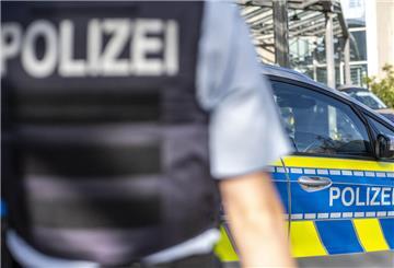 Ein Polizist steht vor einem Streifenwagen. In Bremerhaven hat eine Seniorin mit ihrem Gehstock auf Mitarbeiter eines Supermarkts eingeschlagen.