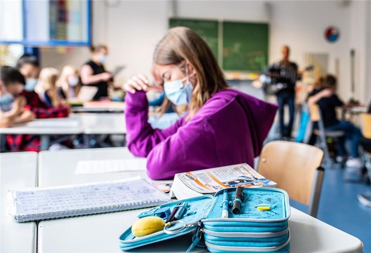 Kind mit Maske in Klassenraum