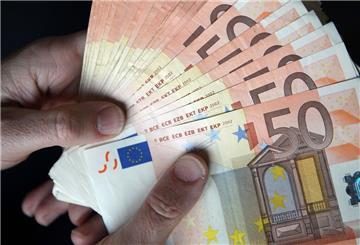 Eine Person hält zahlreiche 50-Euro-Scheine in den Händen. 