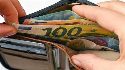 Geldscheine stecken in einer Brieftasche.