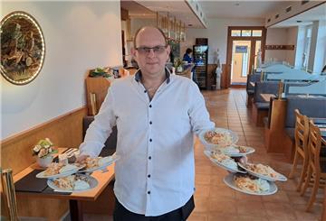 Gelernt ist gelernt: Georgius Stavrakoudis balanciert in seinem neuen griechischen Restaurant „Hellas“ in Lunestedt acht Tellern mit Bohnen- und Krautsalat sowie Tzatziki. 
