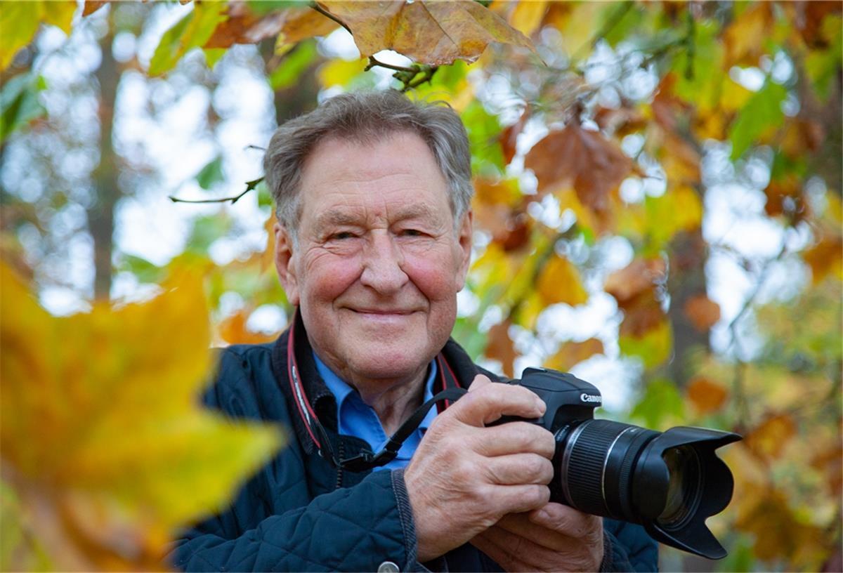 Jochen Wrede mit Fotokamera in der Hand. 