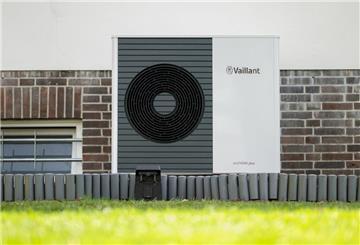 Eine Wärmepumpe steht an einer Hauswand.