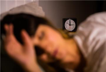 schlafende Frau vor Wecker
