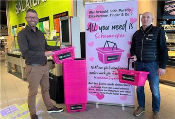 Geschäftsführer Marko Jungnickel und Marktleiter Jens Kaminski vor dem Aufsteller mit den pinken Einkaufskörben.