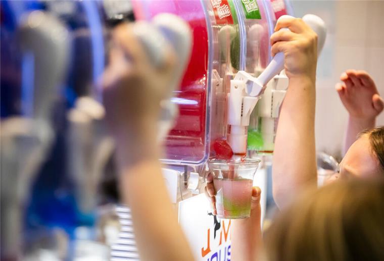 Krampfanfälle und Bewusstlosigkeit: So gefährlich ist Slush-Eis für Kinder PRODUKTION - 23.01.2024, Berlin: Kinder befüllen ihre Becher bei einem Kindergeburtstag mit Slush-Eis in verschiedenen Geschmackssorten. (zu dpa: «Studie: Schon Kleinkinder essen zu süß und ungesund») Foto: Christoph Soeder/dpa +++ dpa-Bildfunk +++