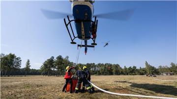 Geübt wurde unter anderem einen Behälter unter einem Helikopter im Schwebeflug mithilfe eines Füllrohrs mit Löschwasser zu füllen.