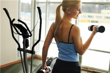 Frau mit Hanteln im Fitnessstudio