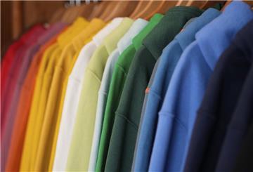 Bunte Pullover hängen an einer Kleiderstange.