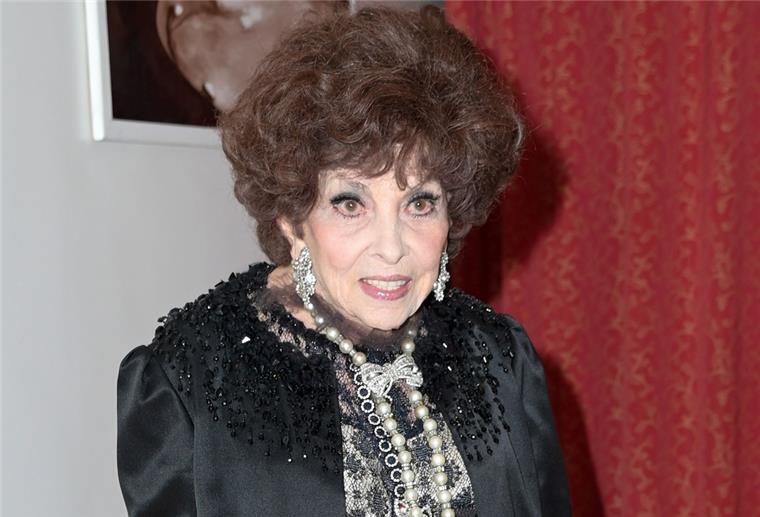 Gina Lollobrigida, italienische Schauspielerin, trägt auffällige Ohrringe, ist stark geschminkt und hat toupierte Haare.