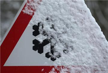  Schneebedeckt ist ein Warnschild das auf Schneeglätte hinweist. 
