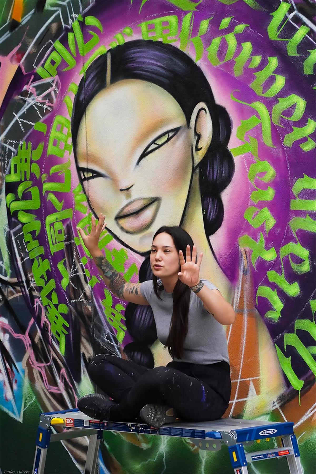 Internationale Graffitikunst in Bremerhaven von Elena Ohlander und Dosar1 Elena vor Graffiti
