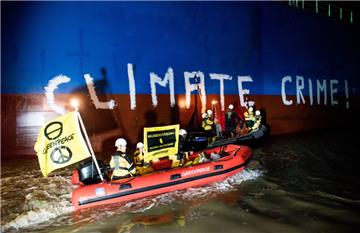 Greenpeace-Aktivisten bemalen auf der Weser bei Brake das Frachtschiff "Hiroshima Star" mit dem Schriftzug "Climate Crime" (Klimaverbrechen). Mit der Aktion protestiert die Organisation gegen den Import von Soja aus zerstörten Wald- und Savannengebieten.