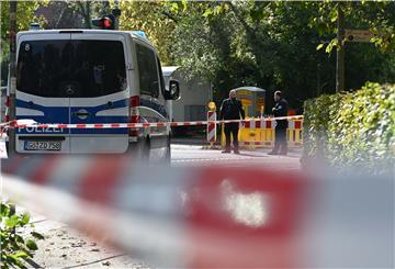 Einsatzfahrzeuge der Polizei stehen hinter einem Absperrband. 