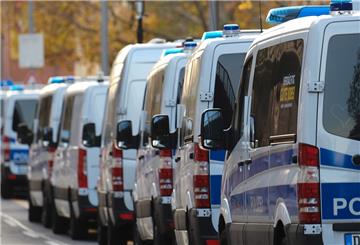 Polizeifahrzeuge stehen bei einem Einsatz vor Häusern.