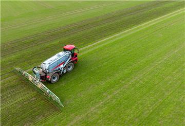Ein Landwirt bringt mit seinem Gespann Gülle im sogenannten Schleppschuh Verfahren auf einem Feld aus