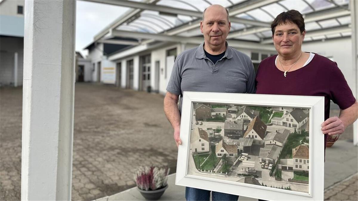 Ende für „Auto Lohse“ in Dorum - Traditionsbetrieb schließt nach fast 100 Jahren Zwei Menschen mit einem großen Bild in den Händen.
