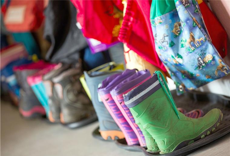 Gummistiefel für Kinder stehen in der Garderobe einer Kindertagesstätte. In Bremerhaven muss eine Einrichtung nun vorübergehend geschlossen werden.