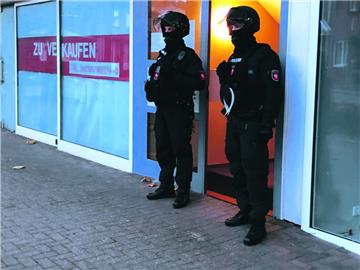 Gut gerüstet: Polizisten sperren den Zugang zu der Wohnung ab, die Beamte am Morgen durchsuchten.