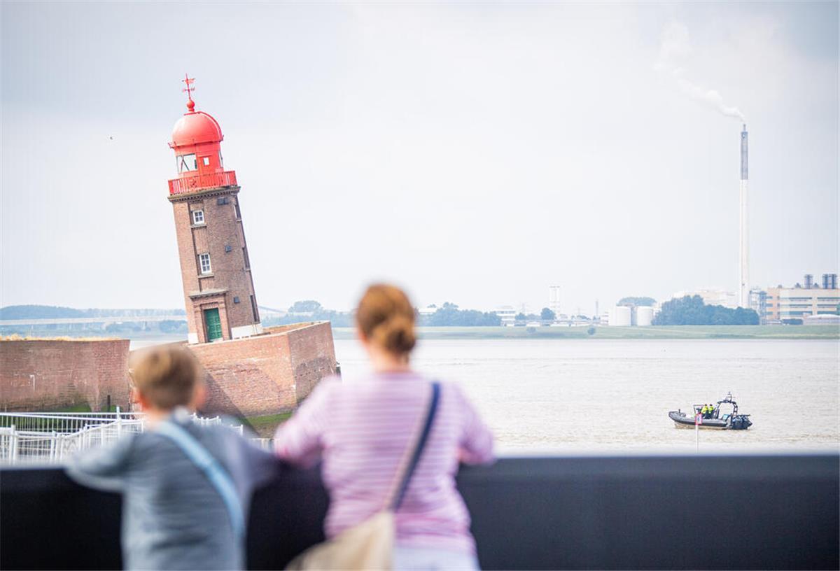 Bremerhavener Nordmole: Neubau soll noch in diesem Jahr starten Zwei Menschen blicken auf den schiefen Molenturm.
